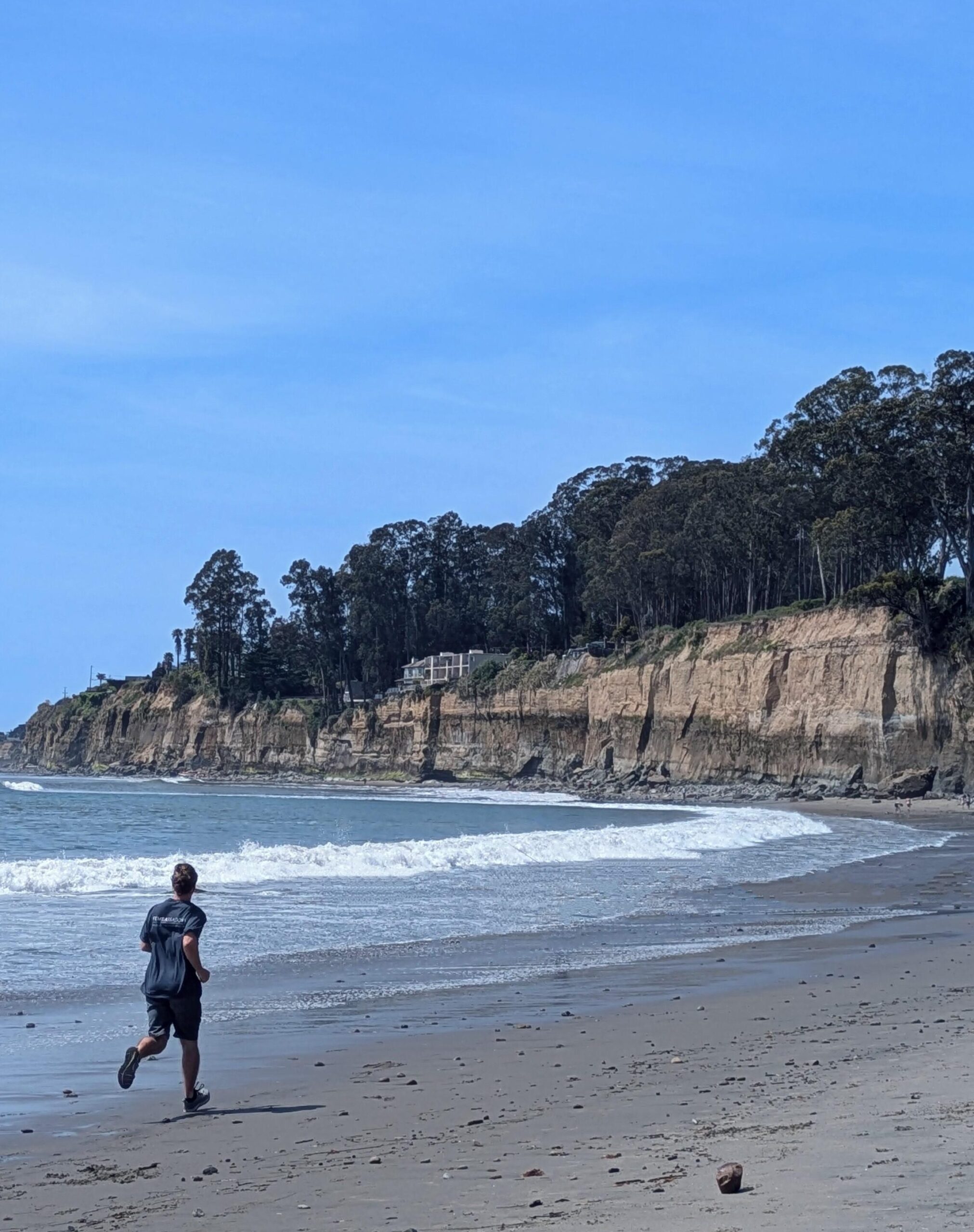 This is an image of a person running parallel to the ocean water, as a way of showing the person not entering the water while still being close to it. Its purpose is to show how sprint coaching is similar to somatic coaching, but not quite the same experience.